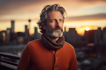 Portrait of a blissful man in his 50s dressed in a warm wool sweater in vibrant city skyline