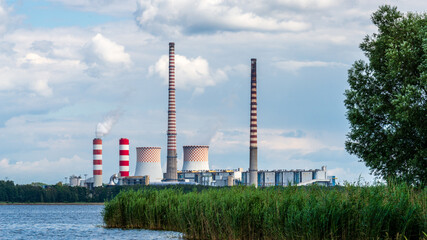 Rybnik power station at Lake Rybnickie (Poland). White smoke comes up a chimney close to the characteristic red and white checkered cooling towers.