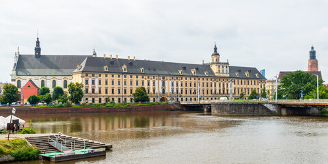 University of Wrocław, Poland, viewed from across the Oder River on a cloudy summer day. The yellow brick building has been a university since 1702.