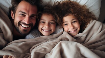 Happy Caucasian family of four on bed with sherpa blanket. Parents enjoying the weekend with their daughter and son. Happy family lounging in bed in the morning