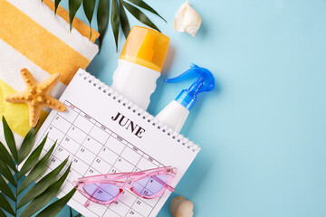 Flat lay of a June calendar with beach vacation accessories, emphasizing vacation planning and seasonal activities. Suitable for marketing summer holiday promotions - obrazy, fototapety, plakaty