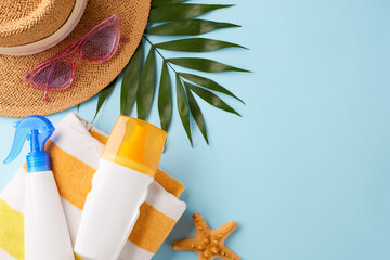 Overhead shot of a beach towel, sunscreen, and sunglasses, capturing the essence of preparing for a...