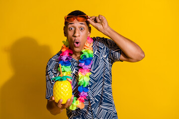 Photo of impressed funny guy wear print shirt hawaii necklace enjoy fruit juice isolated yellow color background