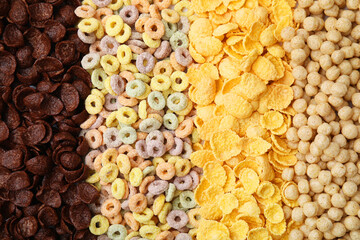 Different types of breakfast cereals as background, top view