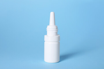 Bottle of medical drops on light blue background