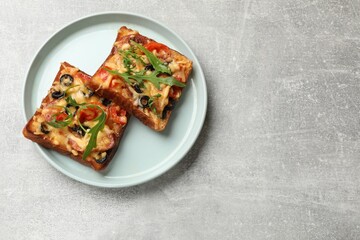 Tasty pizza toasts served on grey table, top view. Space for text