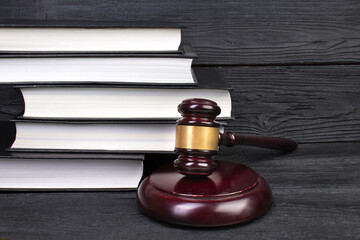 Law concept - Open law book with a wooden judges gavel on table in a courtroom or law enforcement...