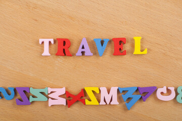 TRAVEL word on wooden background composed from colorful abc alphabet block wooden letters, copy...