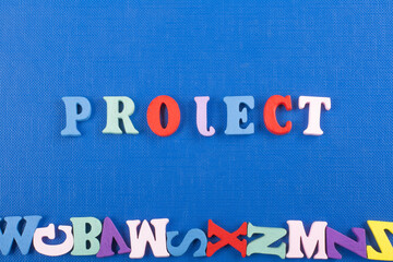 PROJECT word on blue background composed from colorful abc alphabet block wooden letters, copy...