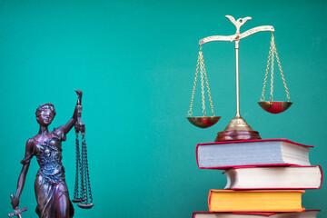 Law concept - Open law book, scales, Themis statue on table in a courtroom or law enforcement...