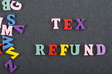 TEX REFUND word on black board background composed from colorful abc alphabet block wooden letters, copy space for ad text. Learning english concept.