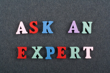 ASK AN EXPERT word on black board background composed from colorful abc alphabet block wooden...