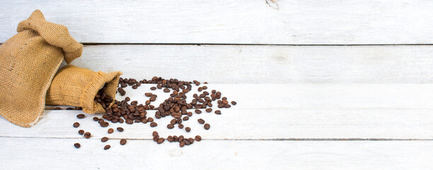 Sack with brown roasted coffee beans. Burlap sack. Scoop with grains. Banner.