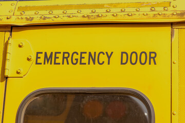 Tylne drzwi w autobusie. Wyjście awaryjne z żółtego autobusu szkolnego. Stary szkolny amerykański żółty autobus. Wyjście awaryjne z tyłu autobusu. - obrazy, fototapety, plakaty