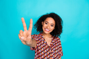 Photo of adorable pretty lady wear print shirt showing you v-sign empty space isolated blue color background