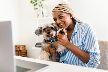 Woman, dog waving during video call at home