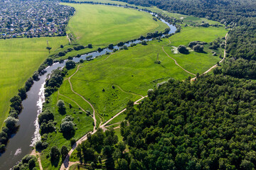 Aerial landscape with a view of a river surrounded by green fields