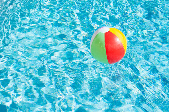 Beach ball floating on water in swimming pool