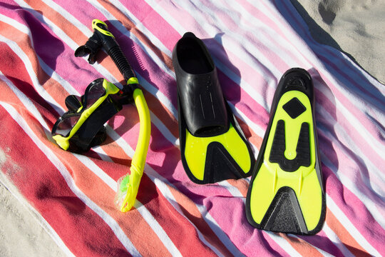 Snorkel mask and fins on beach towel