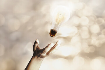 surreal lit light bulb flies thrown by a person, concept of idea and creative energy