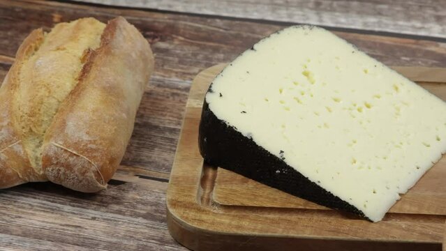 tranche de fromage : tomme noire des Pyr&eacute;n&eacute;es, en gros plan, sur une table