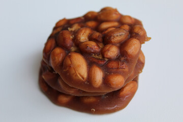 Gula kacang, or Ampyang, is a traditional snack from Indonesia, made from roasted peanuts and brown sugar. Isolated on white background