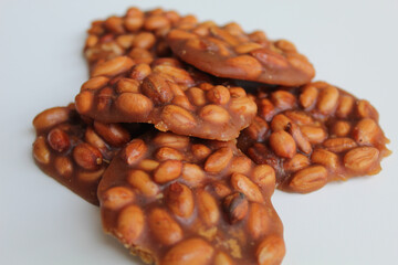 Obraz premium Gula kacang, or Ampyang, is a traditional snack from Indonesia, made from roasted peanuts and brown sugar. Isolated on white background