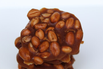 Gula kacang, or Ampyang, is a traditional snack from Indonesia, made from roasted peanuts and brown sugar. Isolated on white background