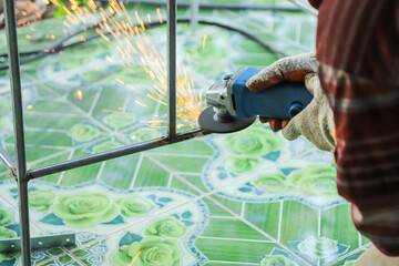 hand using angle grinder in metal welding construction in working safety