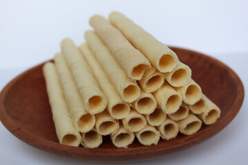Egg rolls, original flavor. Rolled thin crepes. On wooden plate. Isolated on white background