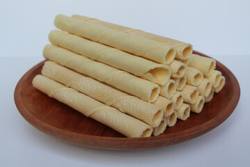 Egg rolls, original flavor. Rolled thin crepes. On wooden plate. Isolated on white background