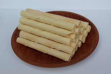 Egg rolls, original flavor. Rolled thin crepes. On wooden plate. Isolated on white background