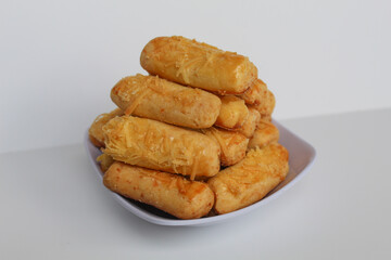 Kaasstengels or Kastengel, is Dutch influenced Indonesian cheese cookies in the form of sticks. Isolated in white background