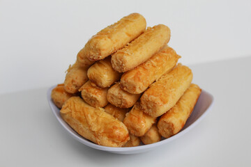 Kaasstengels or Kastengel, is Dutch influenced Indonesian cheese cookies in the form of sticks. Isolated in white background