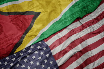 Obraz premium waving colorful flag of united states of america and national flag of guyana on the dollar money background. finance concept.