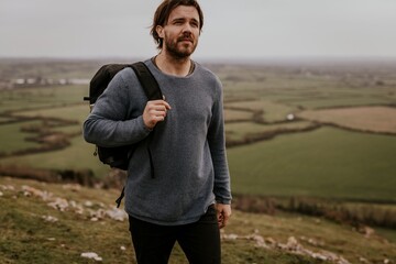 Man wearing long sleeve shirt, walking on hill