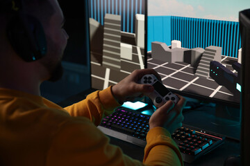 Man playing video games with controller at table indoors