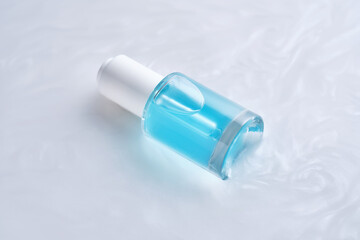 Bottles of serum with a dropper in liquid with pearl tints.