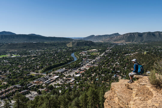 Usa, Colorado, Durango, Woman sitting on ledge in San Juan Mountains