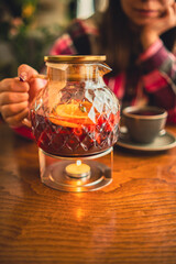 Jug of tea on rack with burning candle.