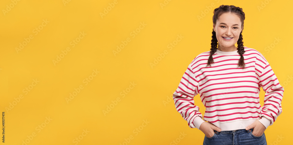 Wall mural Smiling woman with braces on orange background. Banner design with space for text