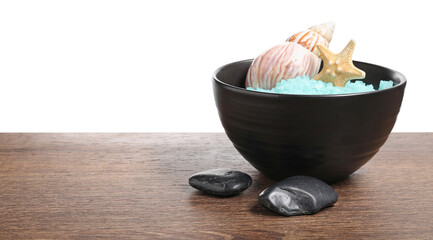 Light blue sea salt in bowl, spa stones, starfish and seashell on wooden table against white...