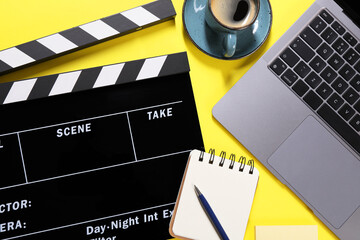 Flat lay composition with movie clapper on yellow background