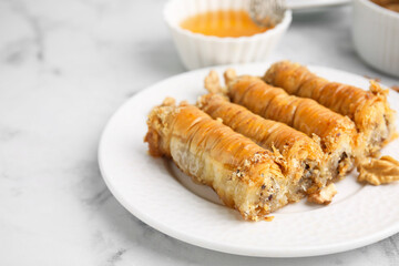 Eastern sweets. Pieces of tasty baklava on white marble table, closeup. Space for text