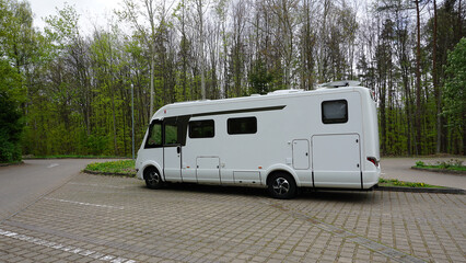 The one white modern campervan recreational motor home parked at road. Motorhome campground...