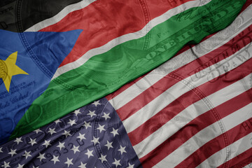 waving colorful flag of united states of america and national flag of south sudan on the dollar...