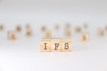 IFS acronym. Concept of Internal Family Systems written on wooden cubes isolated on white background