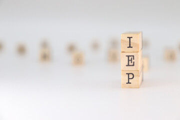 IEP Acronym. Concept of Individual Education Plan written on wooden cubes isolated on white...