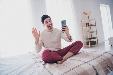 Photo of cheerful man speaking phone hello morning in comfy flat white day light room interior...