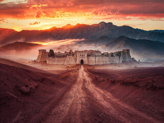 Dirt desert road leading to a ancient city civilization. Vibrant sunset sky. Fictional middle eastern biblical city castle ruins. Arid dry landscape with mountains. Cities such as: Bethany, Antioch